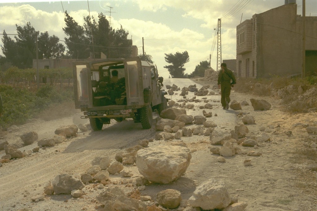 AN IDF PATROL REMOVING ROCKS FROM STREET ON THE OUTSKIRTS OF HEBRON. ôèøåì ùì çééìé öä"ì áôàúé çáøåï. áöéìåí, â'éô öáàé îôìñ ãøëå áéï ñìòéí ùäåùìëå òì îðú ìçñåí àú ãøëí ùì ëåçåú äáéèçåï.